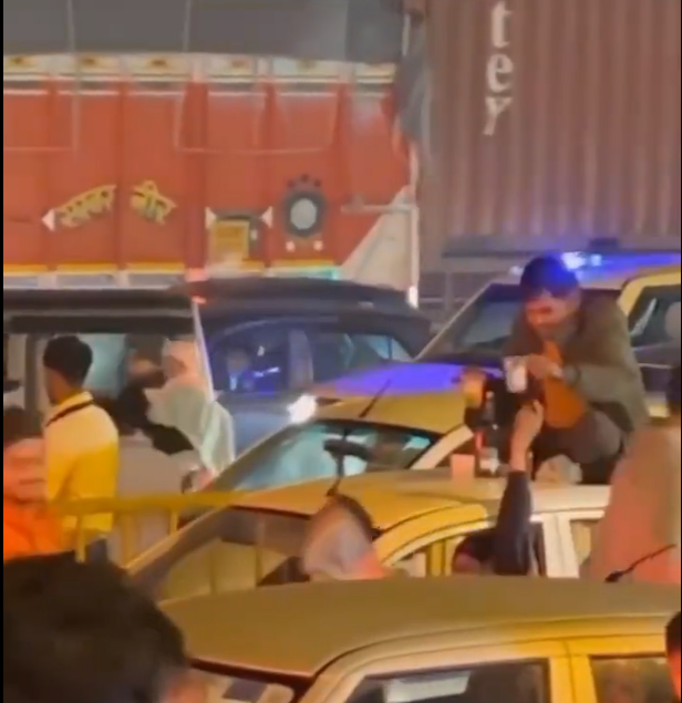 Viral Video: Man Drinks Alcohol On Car’s Roof in a busy Traffic Jam In Gurugram